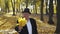 Senior man dressed in a suit and hat shows maple leaves' bouquet at camera