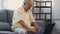 Senior man dressed wear eyeglasses sitting on chair working on laptop