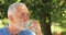 Senior man drinking water in glass at garden