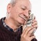 Senior man expressing happiness while posing with dollar and euro bills