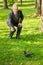 Senior man feeds dove in park