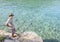 Senior man fishing in the Adriatic Sea from the bank. Summer, sun, sea, fishing rods. Azure clear sea water