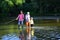 Senior man fishing with son and grandson. Grandpa and grandson are fly fishing on river. Men hobby. Summer day. Family