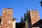 Senior man with gas powered leaf blower cleaning roof gutters on an apartment building, fall maintenance