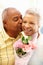 Senior man giving flowers to wife