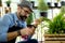 A senior man or grandfather with a mustache and beard enjoys gardening for the tree at home after retirement