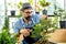 A senior man or grandfather with a mustache enjoys gardening for the tree at home after retirement