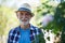 Senior man in hat standing in garden