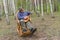 Senior man is having rest in birch forest