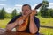 Senior man having rest outdoor playing mandolin