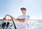 Senior man at helm on boat or yacht sailing in sea