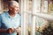 Senior man holding cup and looking out of the window