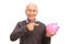 Senior man holding and pointing towards a piggybank