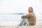 Senior Man On Holiday Sitting On Winter Beach