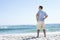 Senior Man On Holiday Standing On Sandy Beach