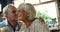 Senior man kissing senior woman in cafe 4k