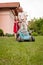 Senior man with lawn mower and child