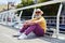 Senior man leaning arms on knees while sitting in downtown