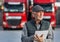 Senior man logistician standing in front of trucks