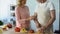 Senior man and loving wife cooking healthy vegetable lunch in kitchen, family