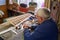 Senior man makes the wing of a radio-controlled aircraft, the construction of the airplane, back view