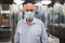 Senior man in mask beside turnstile in subway station