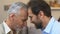 Senior man and mature son touching foreheads, family unity, togetherness concept