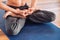 Senior man with a naked torso sitting in a meditative position on a mat in the studio. Copy, empty space for text