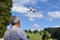 Senior man navigates unmanned aerial vehicle among nature