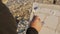 Senior man paints a picture on the beach. Over the shoulder shot of elderly male artist applying paint mixture to canvas