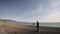 Senior man paints a picture on the beach. Wide shot of elderly male artist sets the picture on the easel on the empty