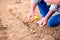 Senior man planting onions in row against dirt, detail