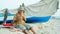 Senior man playing bamboo flute on the beach next to fishing boat