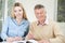 Senior Man Playing Completing Crossword Puzzle With Teenage Gran