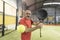 Senior man playing paddle tennis backhand in court