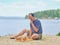 Senior man pondering a move in a game of chess and sitting on the beach near the lake