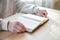 Senior man praying, reading  an old Bible in his hands