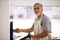 Senior man prepares healthy veggies in the oven,