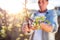 Senior man pruning apple tree in sunny spring garden