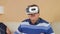 Senior man putting on glasses for the first time virtual reality together with a woman. The man swings his arms and