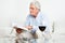 Senior man reading book on couch