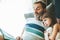 Senior man reading a book to his granddaughter