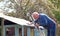 Senior man repairing shed roof.