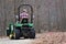 Senior man rides John Deere tractor on edge of rocky path