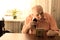 Senior Man Shaving Beard with Razor at the Table