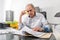 Senior man with sits at a desk, scrolling in a document file