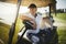 Senior man sitting in his golf cart on a fairway