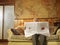 Senior Man Sitting On Sofa Reading Newspaper