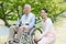 Senior man sitting on a wheelchair with caregiver