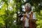 Senior man spending free time outdoors in nature, watching forest animals through binoculars.